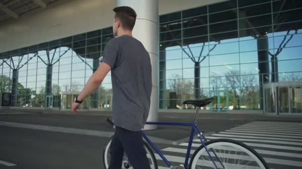 Homem segurando sua bicicleta e andando em câmera lenta — Vídeo de Stock