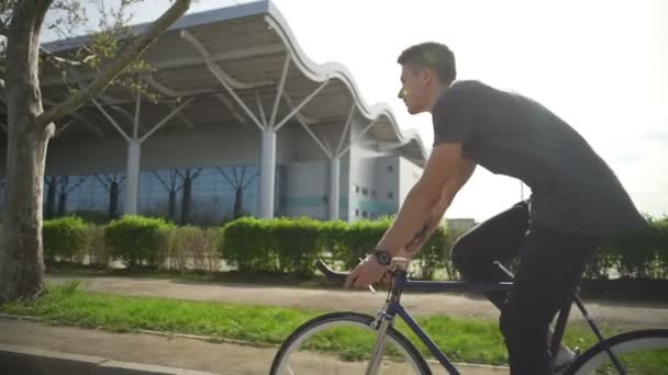 世界杯男子穿着灰色衣服骑他的自行车上街头慢动作 — 图库视频影像