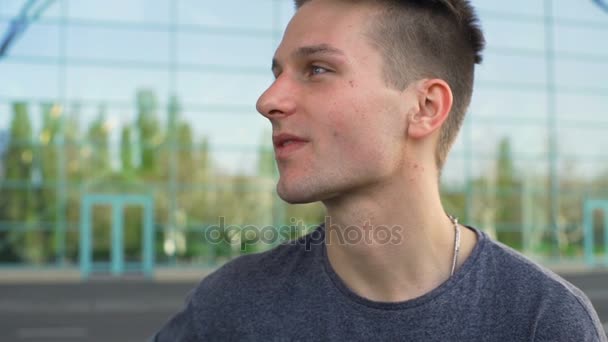 Młody mężczyzna patrząc od hotelu i palenie papierosów zwolnionym tempie — Wideo stockowe