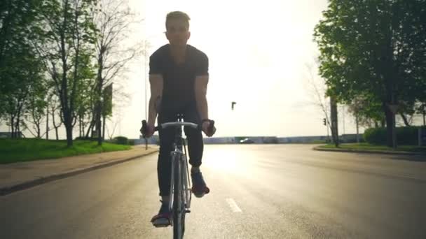 Junger Mann fährt mit Fahrrad in Zeitlupe auf der Straße — Stockvideo