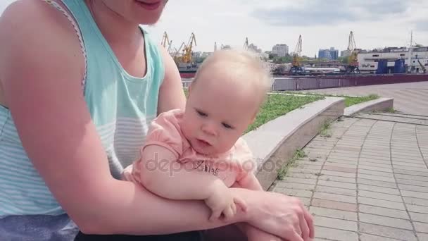 Mooie baby op haar moeders knieën zittend met de drone gefilmd — Stockvideo