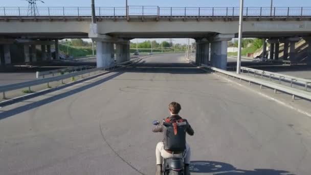 Mann fährt mit Fahrrad unter Eisenbahnbrücke Drohne filmt Zeitlupe — Stockvideo