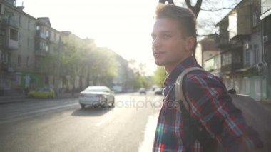 Sınırda duran ve sokak yavaş hareket geçmek için bekleyen adam