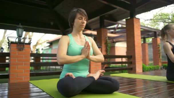 Mulher sentada na postura de lótus e meditando em câmera lenta — Vídeo de Stock