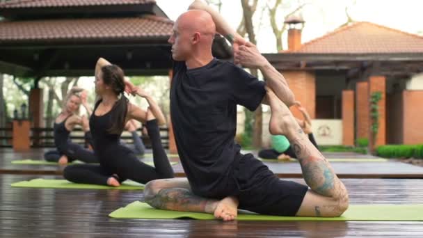 Group of people doing a hard yoga exercise in the yard slow motion — Stock Footage Group of people doing a hard yoga exercise in the yard slow motion Stock Video