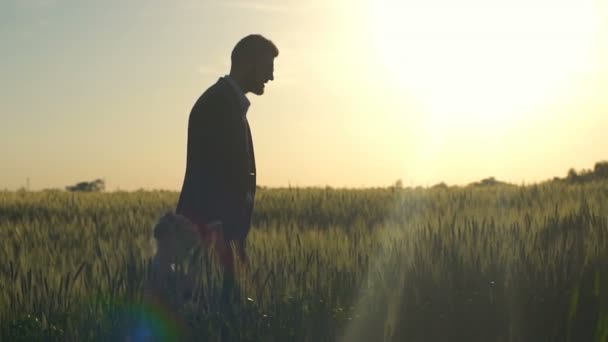 Jonge zakenman lopen met zijn dochter op het veld slow motion — Stockvideo