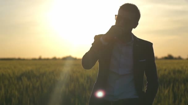 Mladý podnikatel stojící v pšenici a jíst jablko Zpomalený pohyb — Stock video