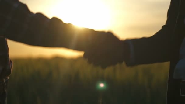 Forretningsmann og bonde tar hverandre i hendene – stockvideo
