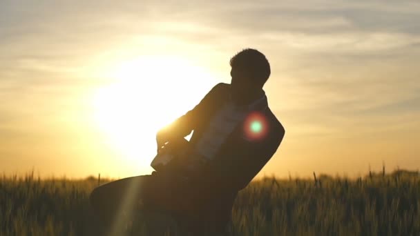 Aantrekkelijke zakenman in suite spelen op ukulele in slowmotion veld — Stockvideo