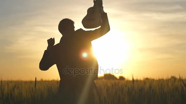 Unrecognisable male in suite danicing with ukulele on a field slow motion — Stock Video