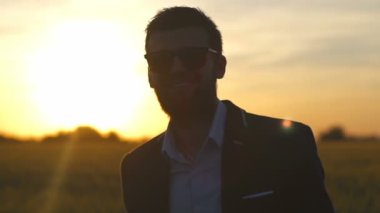 İşadamı sakallı günbatımı ağır çekim alanında olumlu duygular göster