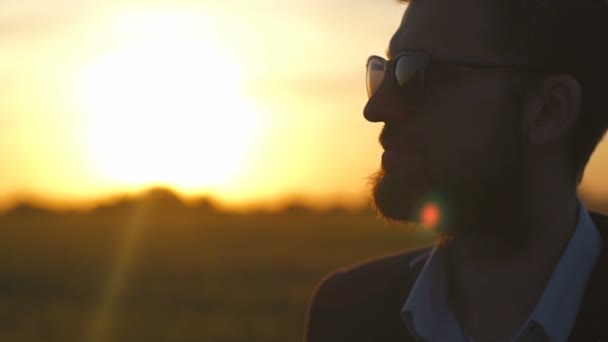 Retrato de un hombre guapo que toca su barbilla campo de atardecer cámara lenta — Vídeo de stock