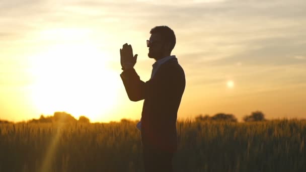 Homem de terno rezar no campo do pôr-do-sol câmera lenta — Vídeo de Stock