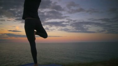 Kadın meditasyon, yoga yaparken gündoğumu ağır çekim sırasında Vrksasana poz