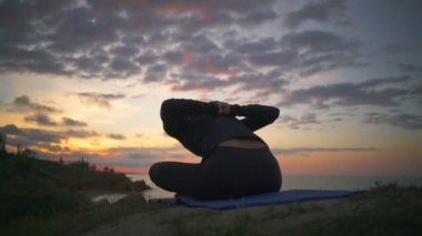 Huzurlu kızı pratik yoga poz meditasyon gündoğumu sahil ağır çekim