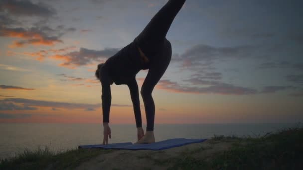 Lugn tjej gör yoga meditera virabhasana sunrise kusten slowmotion — Stockvideo