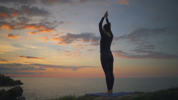 Мирная красивая девушка, занимающаяся йогой, медитирует на намасте, побережье восхода солнца, медленное движение — стоковое видео