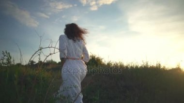 Genç güzel sağlıklı ücretsiz kıvırcık kız yürümek hill soar sahil gündoğumu ağır çekim