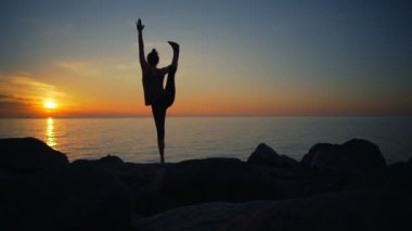 Pratik Yoga doğa şafak ağır çekimde Uçurumdaki sağlıklı genç kadın