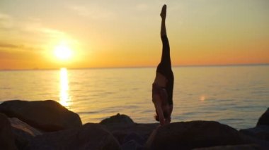 Pratik Yoga sahil seaview şafak yavaş hareket üzerinde sağlıklı genç kadın