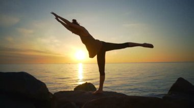 Sağlıklı genç güzel kızı pratik yoga asanas Deniz Sahil gündoğumu ağır çekim