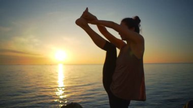 Sağlıklı genç esnek kız meditasyon yoga asanas Deniz Sahil gündoğumu ağır çekim