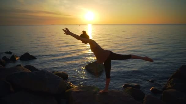 Gesunde junge flexible Frau praktiziert Yoga Asanas Meer Küste Sonnenaufgang Zeitlupe — Stockvideo