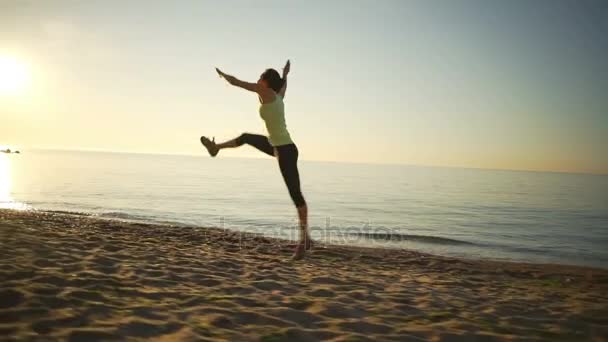 Flexible healthy young girl jump twine cart-wheels sealine sunrise slow motion — Stock Video