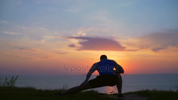 剪影年轻强壮的男人拉伸侧弓步锻炼户外黎明慢动作 — 图库视频影像
