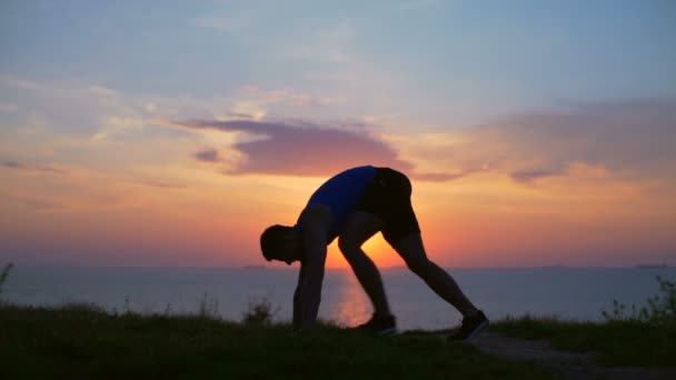 Young strong man stretching  downward dog workout outdoor dawn sea slow motion — Stock Video