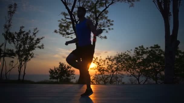 Silueta fuerte Hombre duro Saltar cuerda cambiar piernas entrenamiento al aire libre amanecer slow motion — Vídeo de stock