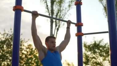 Güçlü çekme yapan erkek uygun yatay park gündoğumu egzersiz yavaş bar ups
