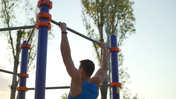 Athletischer Mann macht Klimmzüge am horizontalen Barren Park Sunrise Workout Zeitlupe — Stockvideo