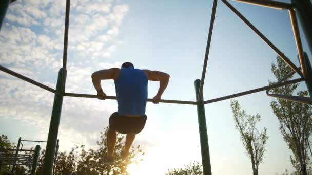 Silný muž dělá svalů ups shybů na hrazdě park cvičení Zpomalený pohyb — Stock video