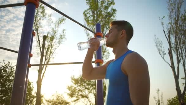 Chico fuerte beber agua limpia de la botella después de los deportes de entrenamiento en cámara lenta — Vídeos de Stock