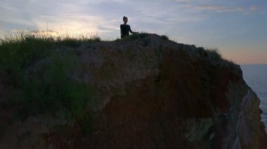 Özgür genç sağlıklı kadın yoga yaparken namaste meditasyon gündoğumu sahil dron görüntüleri