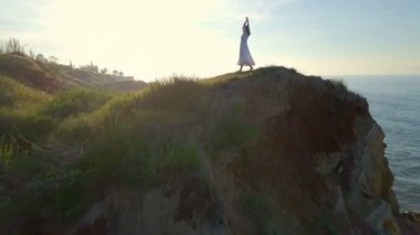 Güzel genç ücretsiz romantik kız dans silah sahil keyfini gündoğumu dron görüntüleri