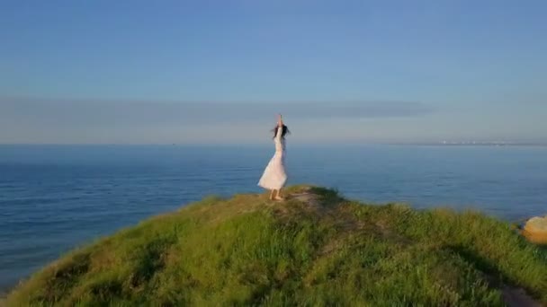 Happy healthy romantic woman circling around on top coast sunrise drone footage — Stock Video