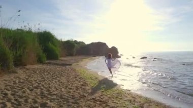 Güzel ücretsiz sağlıklı kadın hızlı beach dalga deniz cliff gündoğumu dron görüntüleri çalıştırmak