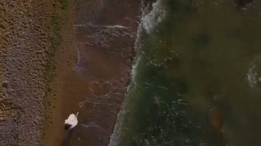 Güzel sağlıklı kadın hızlı beach dalga deniz gündoğumu dron görüntüleri üstten görünüm çalıştırın