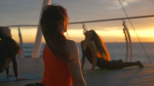 Grupo mujeres urdhva mukha shanasana abajo perro yoga clase mar amanecer cámara lenta — Vídeos de Stock