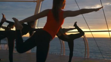 Yoga sınıf genç kadın grup uygulama asana natarajasana gün batımı deniz ağır çekim