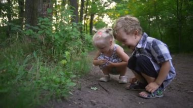 Küçük çocuk ve bodur yol park gülümseyerek oturan kız güneşli hızlı yavaş hareket atlamak