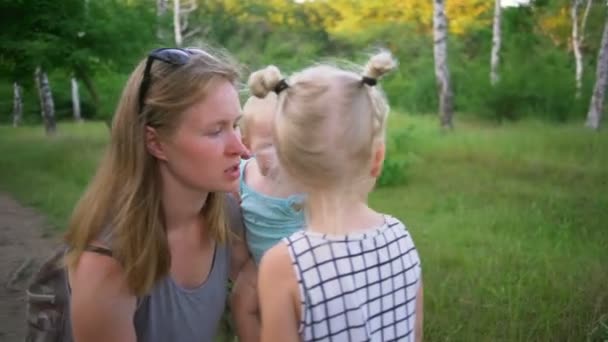 Madre dos bebé niña llora Limpia lágrimas sostienen hija soleado parque rápido cámara lenta — Vídeos de Stock