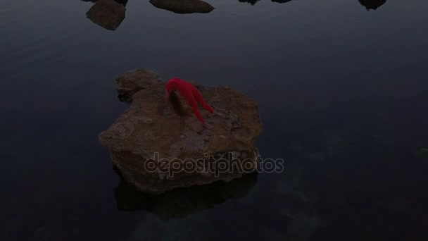Молодая женщина Сделать йога поза мост морской риф Красный костюм рассвет беспилотник съемки антенны — стоковое видео