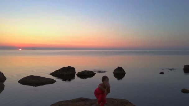 Jeune femme faire Yoga garudasana aigle pose mer récif aube drone images aériennes — Video