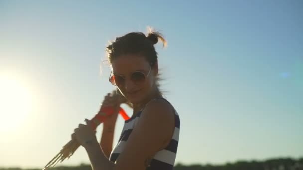 Chica gafas de sol girando con racimo de trigo rojo cinta campo sol rápido cámara lenta — Vídeos de Stock