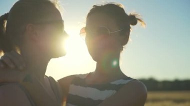 Kız çift sunglass hugs buğday alanı güneşli hızlı yavaş gülümseyerek kapatın