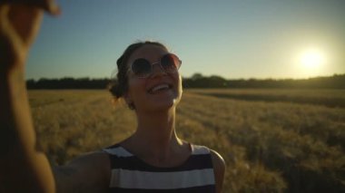 Gülümseyen kız çizgili elbise yapmak selfie buğday alan güneş closeup hızlı yavaş hareket