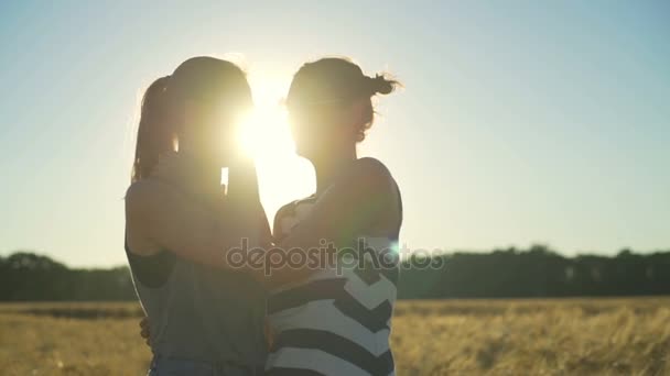 Souriant fille couple rire lunettes de soleil câlins champ de blé ensoleillé rapide ralenti — Video